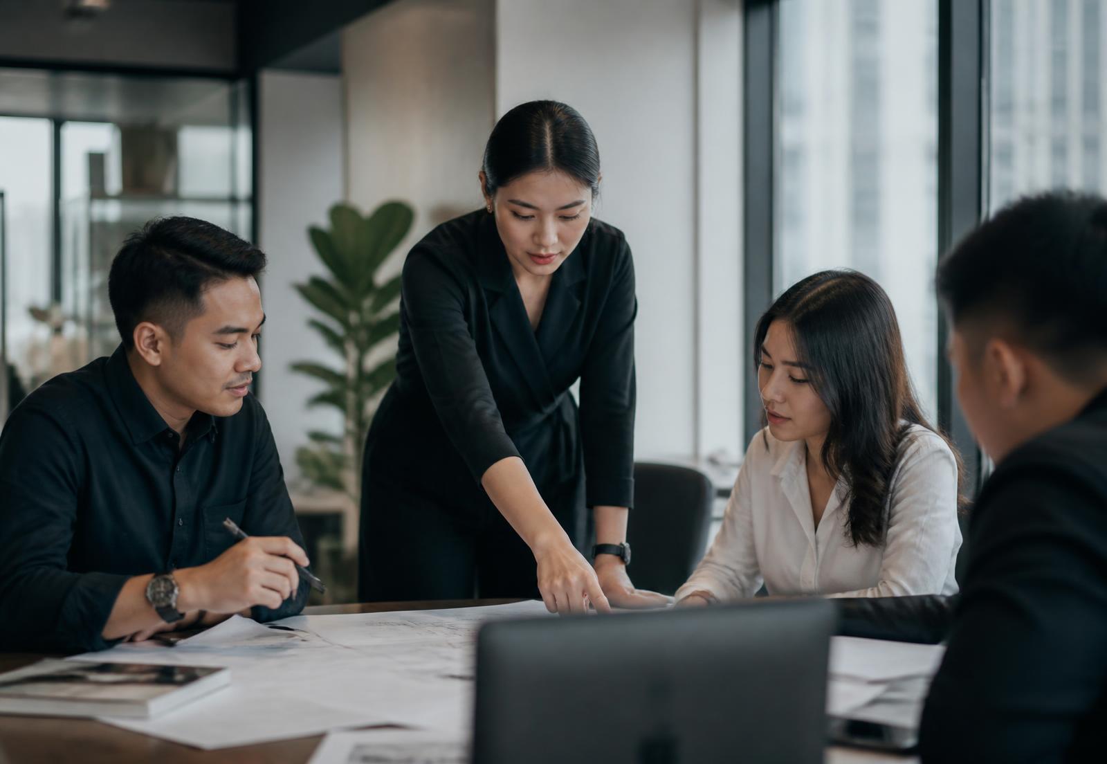 A team of professionals reviewing project plans together in a modern office
